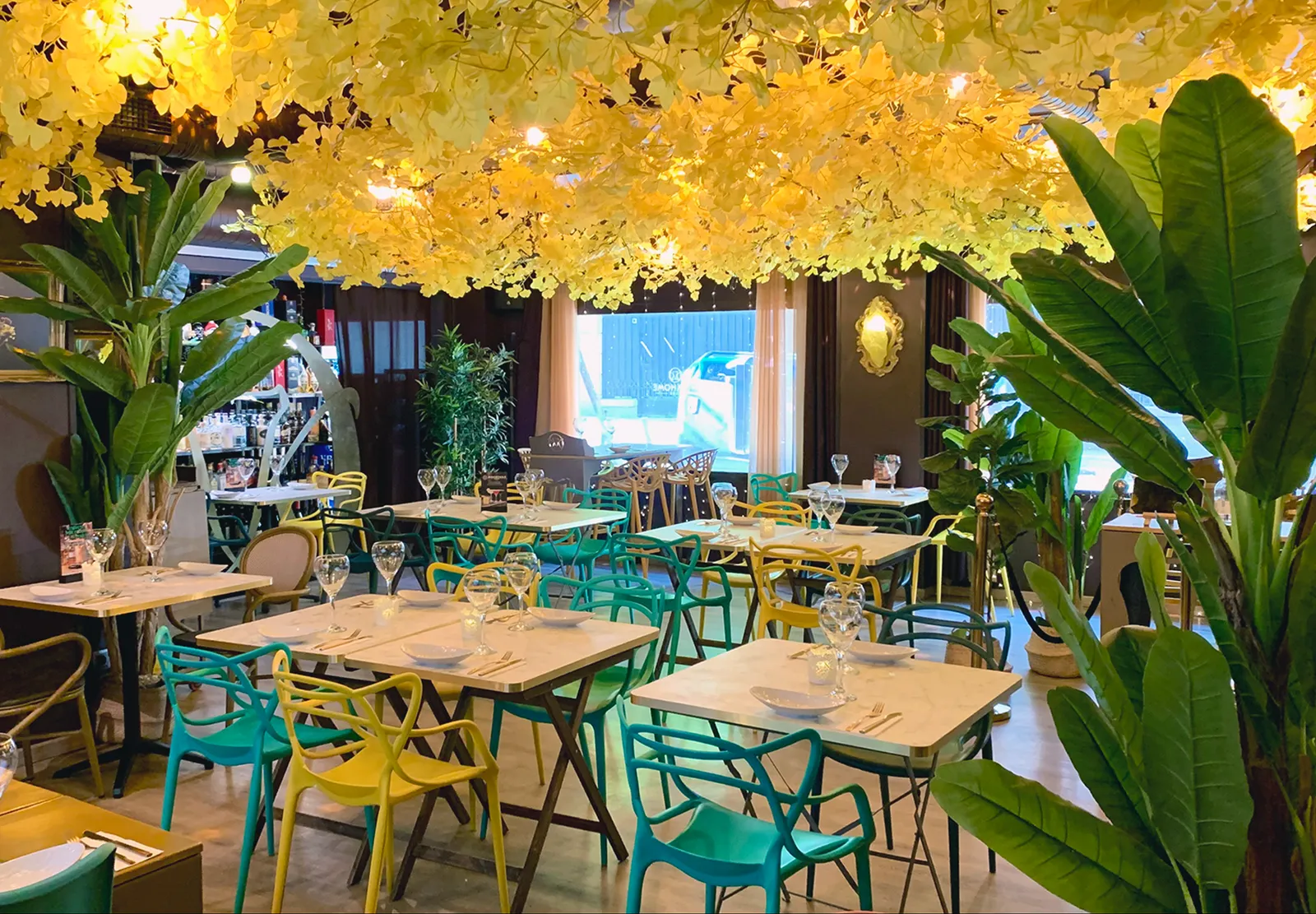 Sala del restaurante Welkhome Club con las mesas preparadas bajo la cubierta de flores